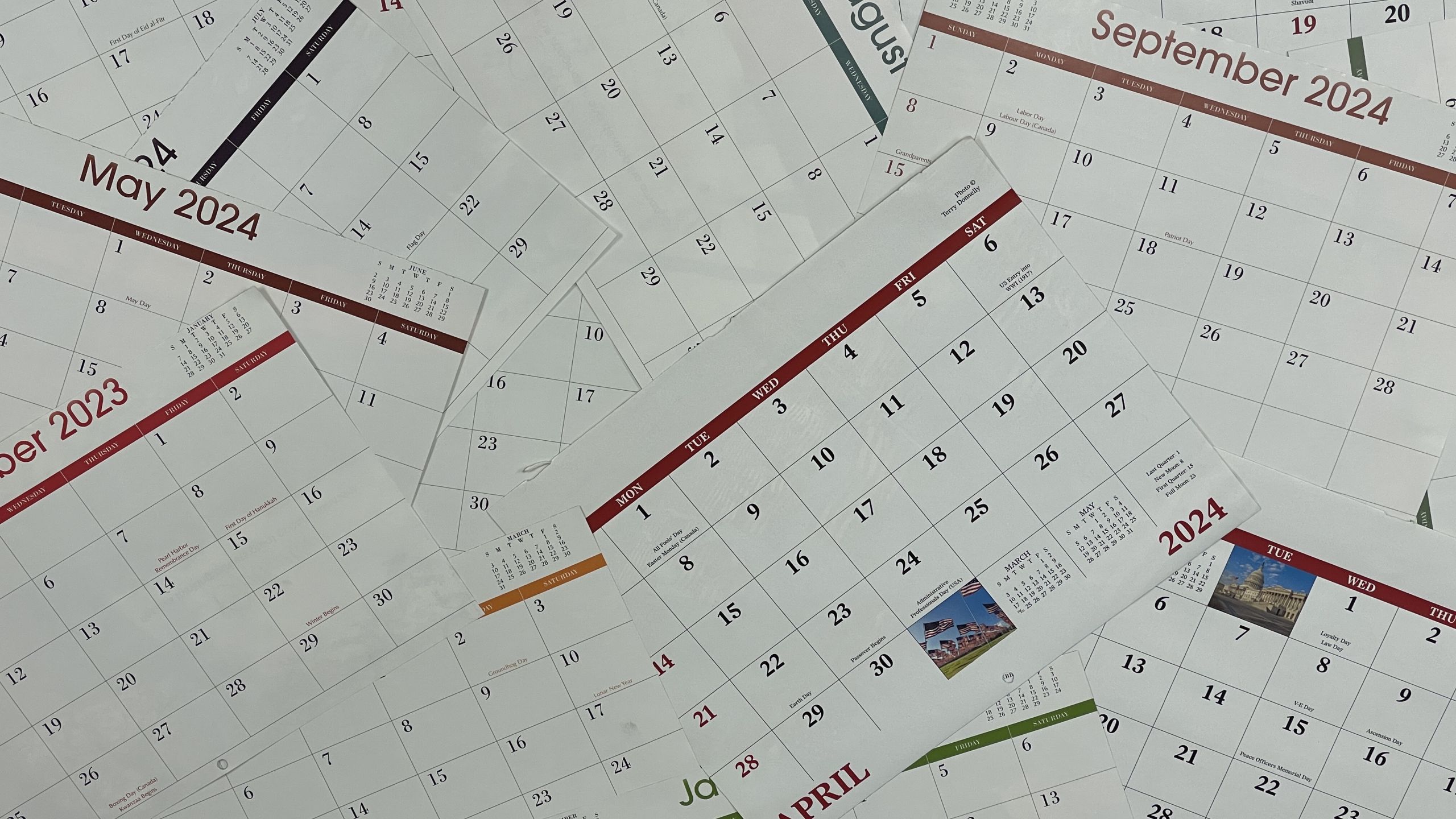 Photo of calendars scattered on a desk.